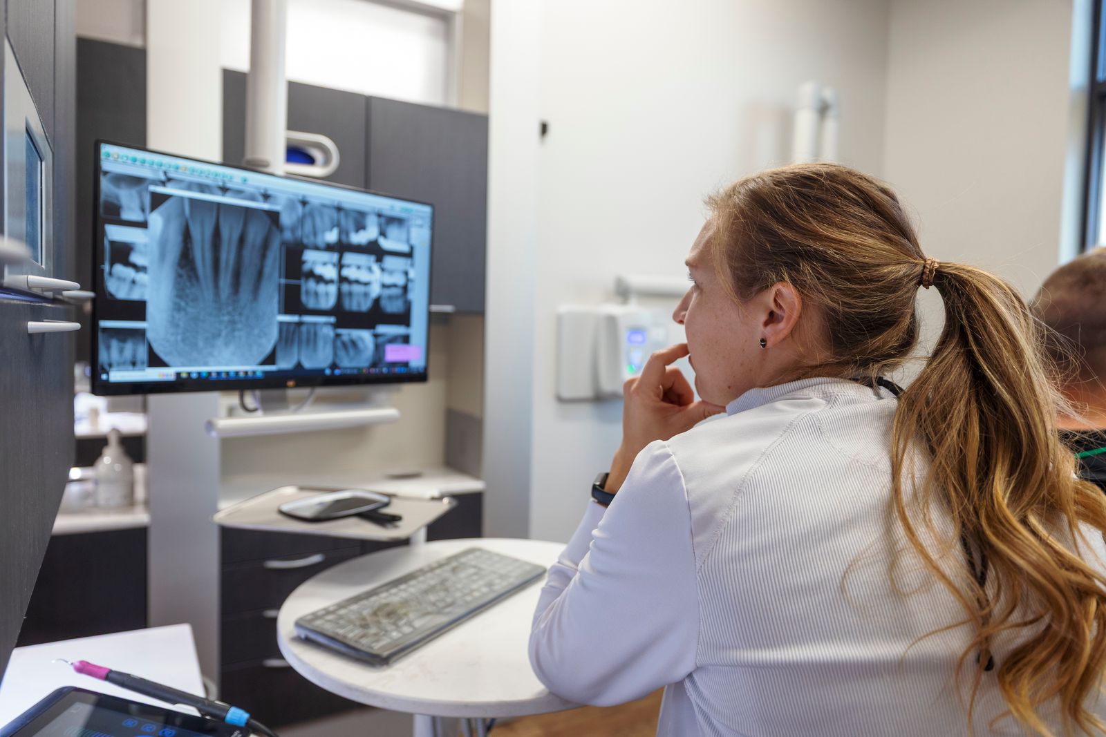 Dental team member reviewing digital x-rays of patient's smile